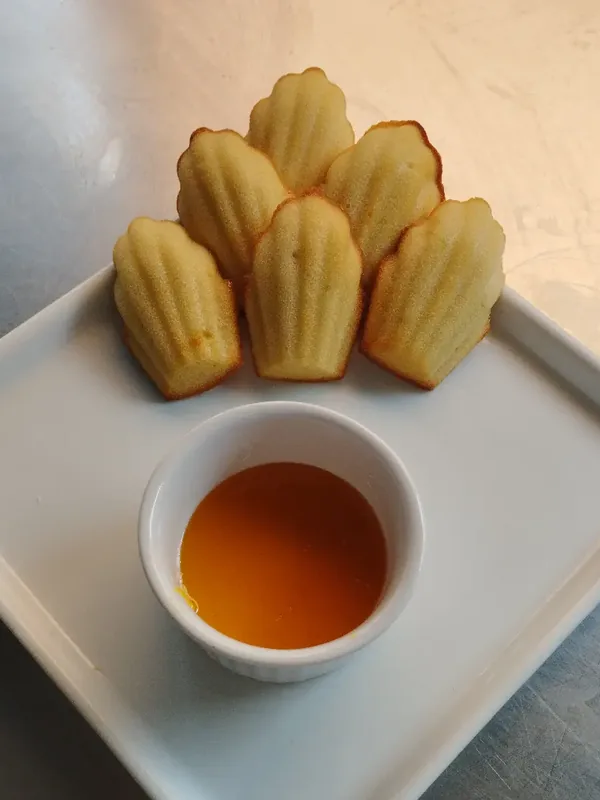 Madeleines douradas servidas com calda
